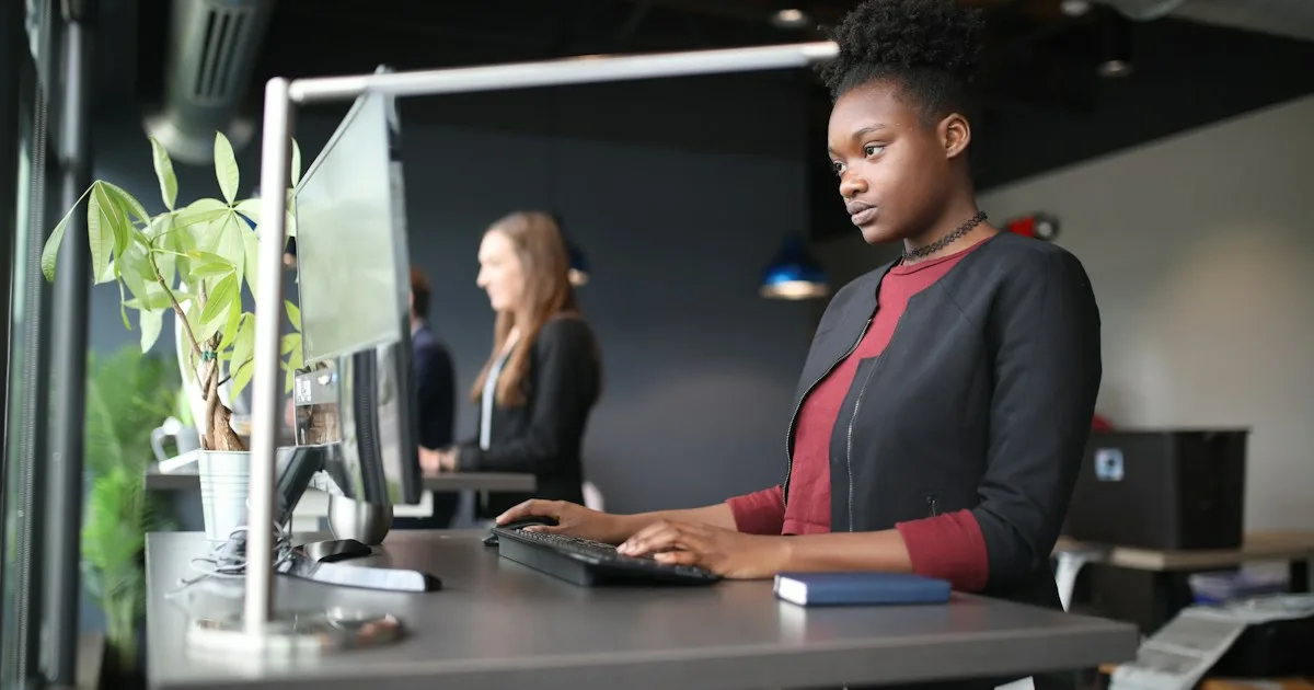 Person standing at a height-adjustable desk while typing - KeyRiser