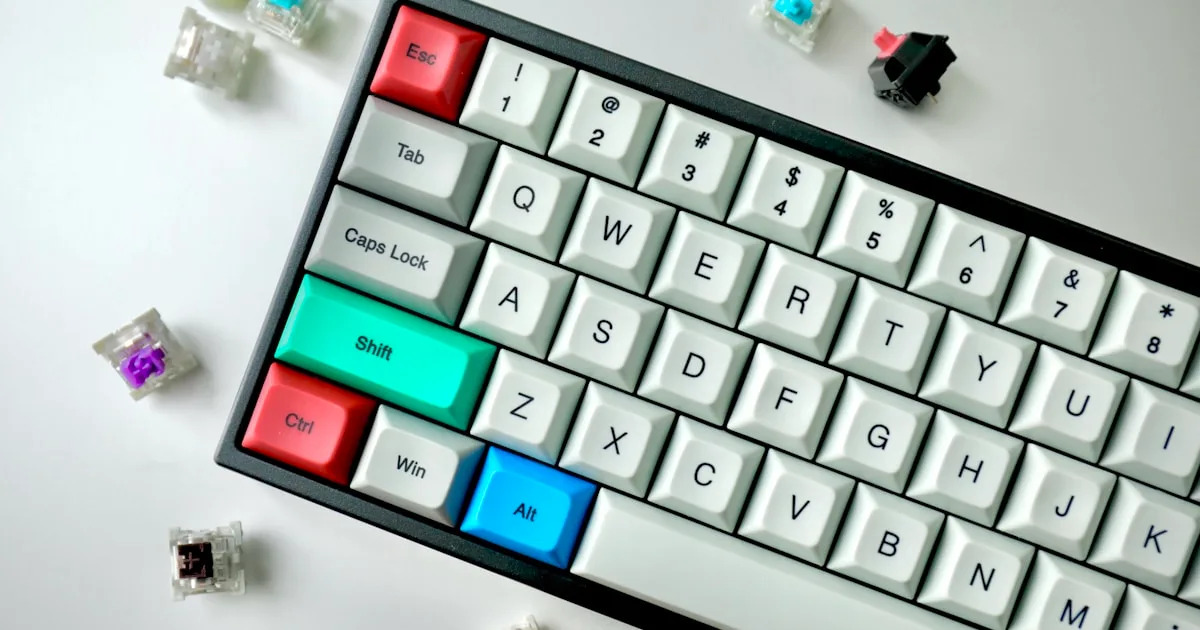 Skrivning kraft videnskab: hænder skrive på en lav-profil Logitech MX Keys tastatur i blødt fokus